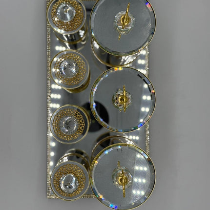 Decorative wall light fixture with circular designs and gold accents on a gray background
