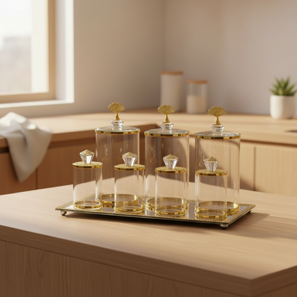 Set of glass canisters with gold accents on a tray in a kitchen setting