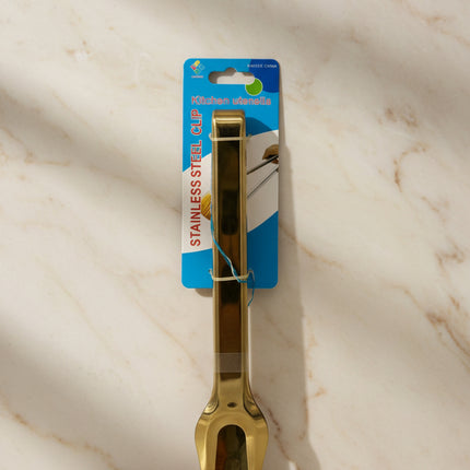 Gold kitchen tong utensil on a white background with packaging