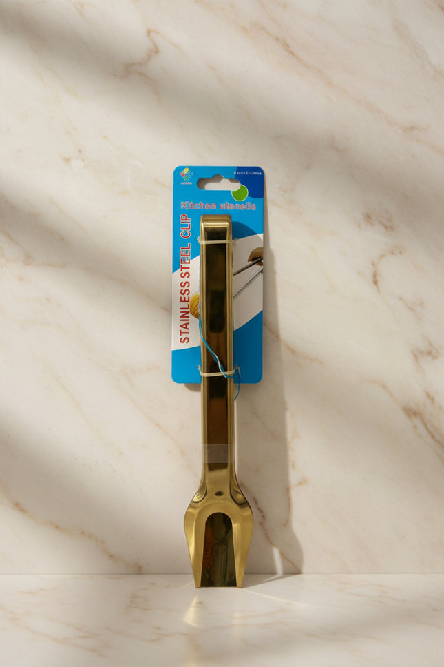 Gold kitchen tong utensil on a white background with packaging