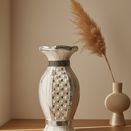 Decorative vase with intricate patterns on a wooden shelf against a beige wall